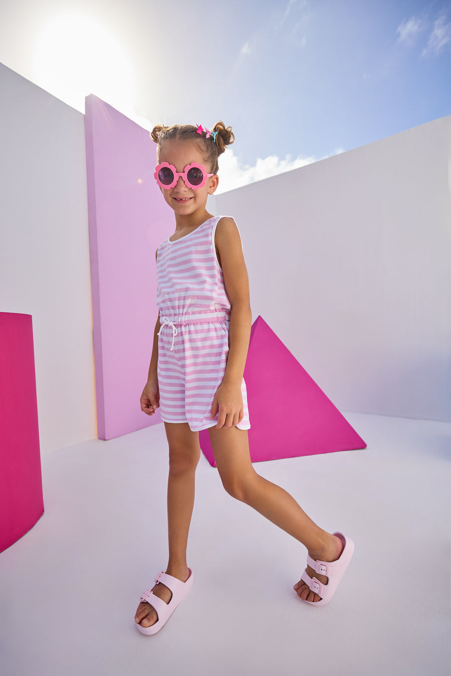 Girls/Tween model can be seen wearing  knit romper in light purple/white stripe. Romper features a keyhole button closure at back , an elastic waistband, and pockets.