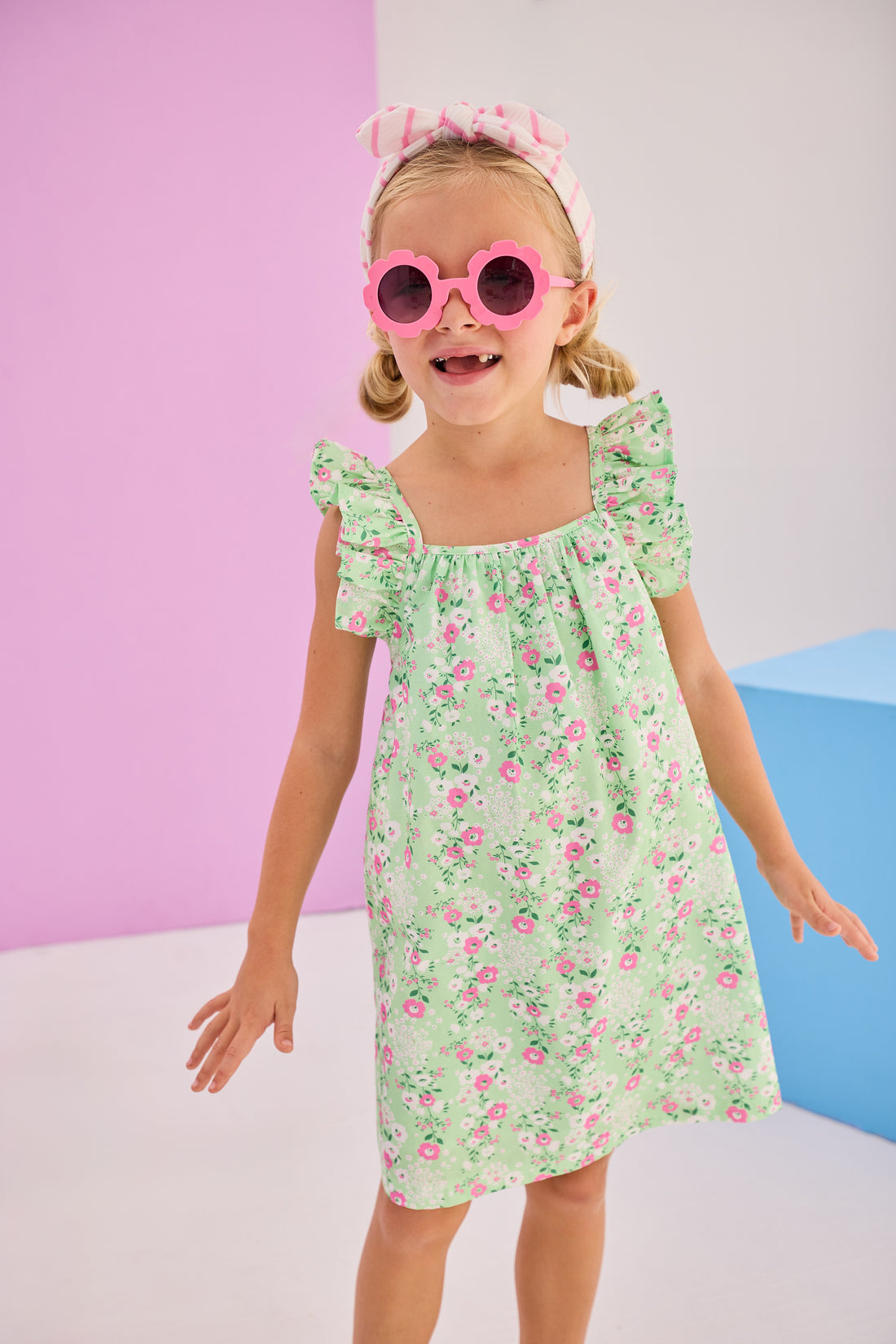 Girls/Tween woven dress in a light green/pink floral print. Dress features adjustable ruffle/angel sleeve straps with button closure at back for a secure but relaxed fit. 