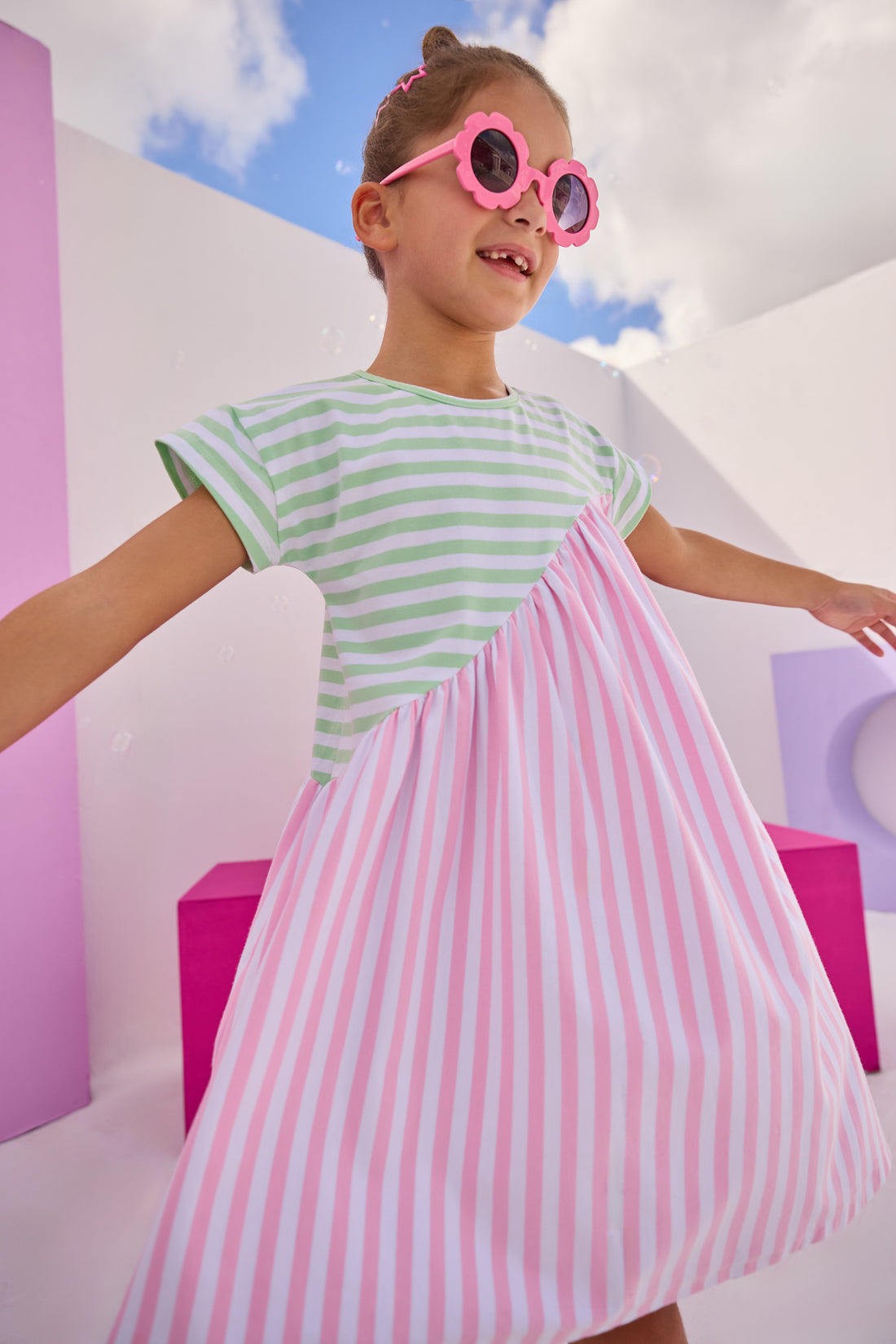 Girls/Tween knit dress in a mixed green and white/pink and white stripe design. Dress is made of a super soft and lightweight knit material and has a fun "swooping" pattern to elevate the look. 