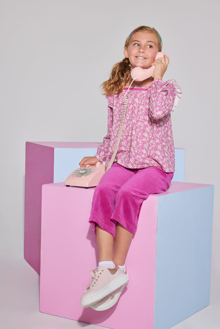 Tween girls square neck, three quarter sleeves with angel sleeve ruffles  in a hot pink floral print paired with cropped velour pants in magenta.