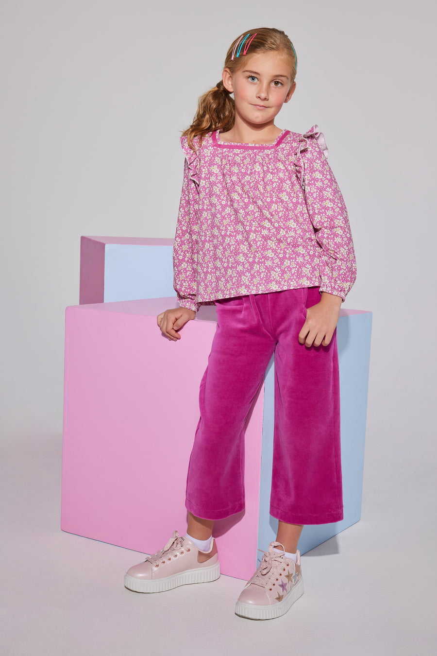 Tween girls square neck, three quarter sleeves with angel sleeve ruffles in a hot pink floral print paired with cropped velour pants in magenta.