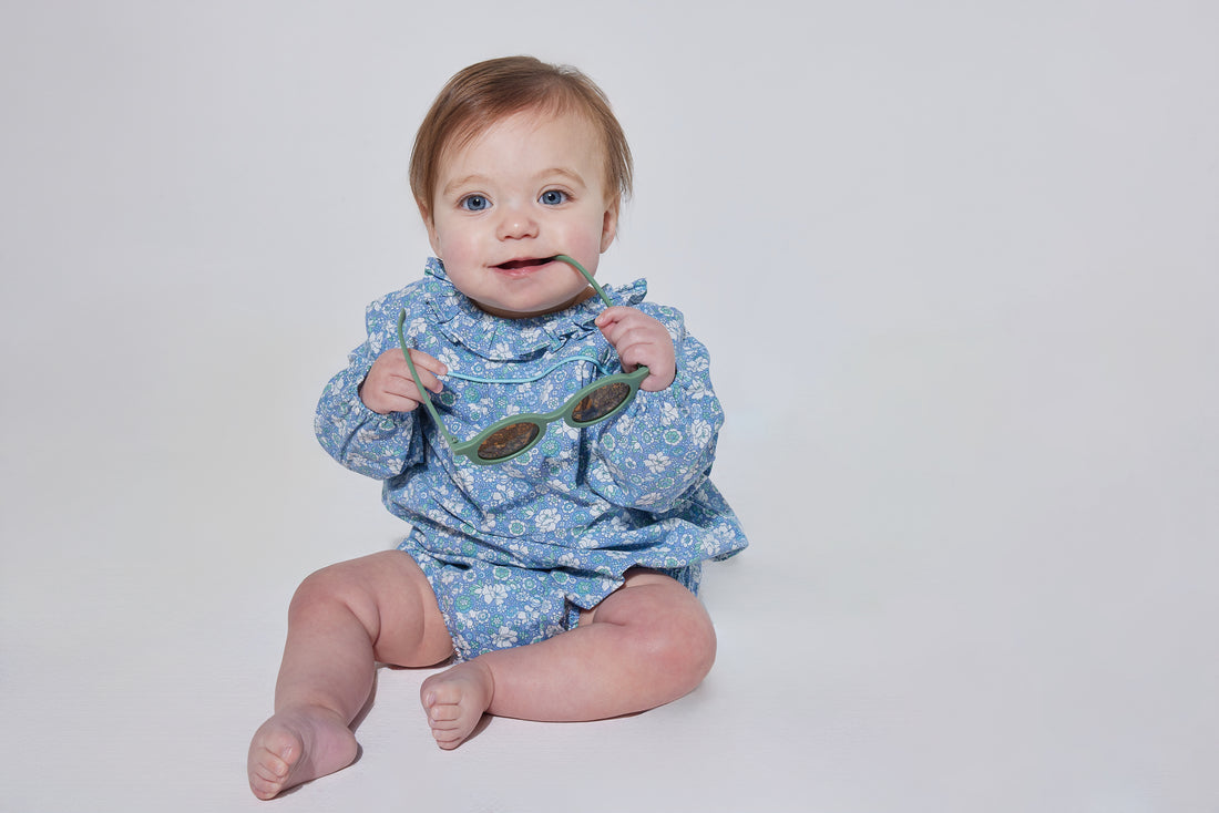 Babygirl longsleeve bubble with elastic wristbands featuring a ruffle neckline with button closures along back and stride in a blue/green/white floral pattern