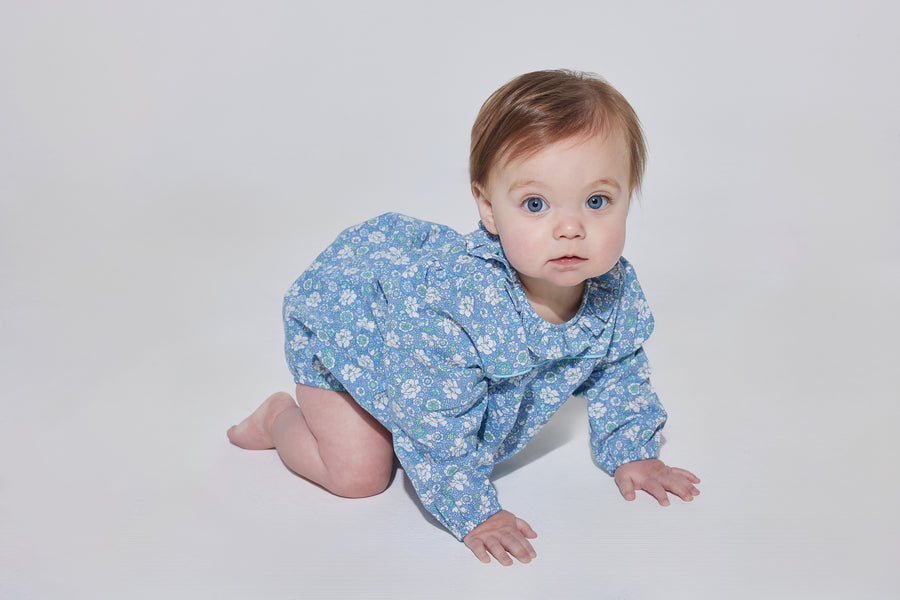 Babygirl longsleeve bubble with elastic wristbands featuring a ruffle neckline with button closures along back and stride in a blue/green/white floral pattern