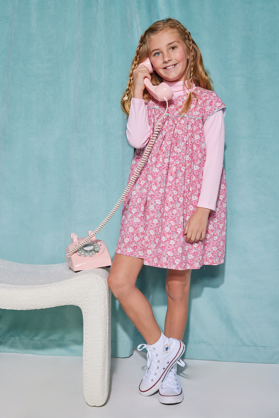 Girls short sleeve dress in pink/aqua/white floral pattern with aqua trim detailing that has button closures along back paired with a turtleneck in light pink underneath.