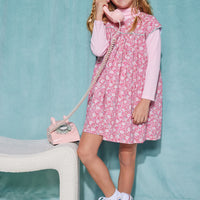 Girls short sleeve dress in pink/aqua/white floral pattern with aqua trim detailing that has button closures along back paired with a turtleneck in light pink underneath.