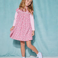 Girls short sleeve dress in pink/aqua/white floral pattern with aqua trim detailing that has button closures along back paired with a turtleneck in light pink underneath.