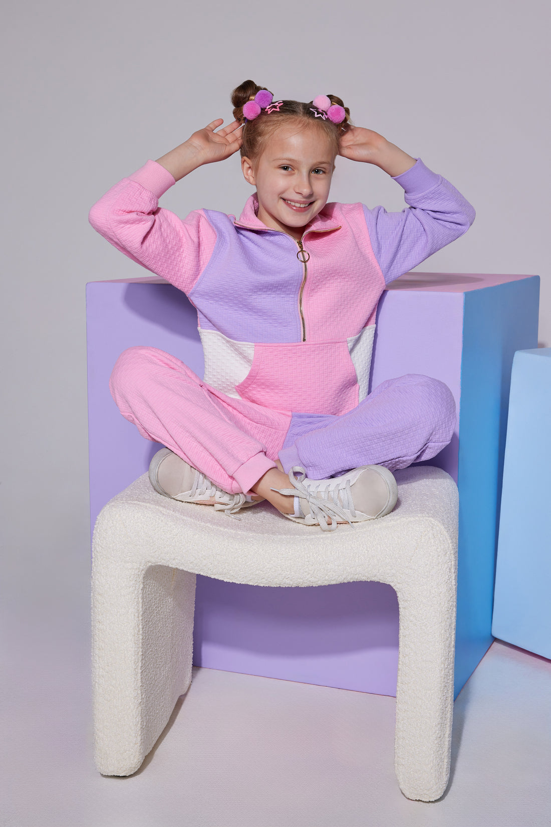 Tween color block quarter zip pullover that features a gold zipper detail and large front pocket in purple/pink/white color block that pairs back with the matching jogger pant that has one pant leg in pink and one leg in lilac to complete the set.