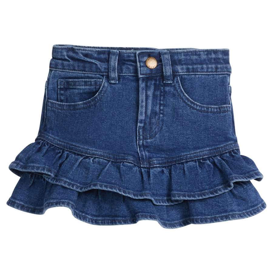 Girls/Tween denim skirt that features a two-tier ruffle at bottom of skirt. Skirt also features a snap button closure and pockets in the front. 