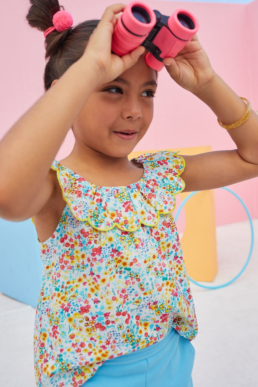 Sleeveless top with scalloped collar and colorful flower pattern.