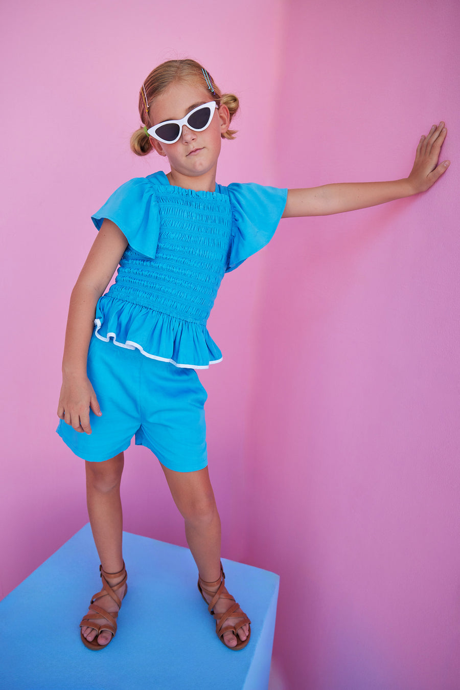 BISBY girl in our India Top in Blue which features ruching/ smocking on the body of the shirt in a super soft rayon material. Shirt is very stretchy but also form fitting and pair perfectly back with our basic shorts in Blue