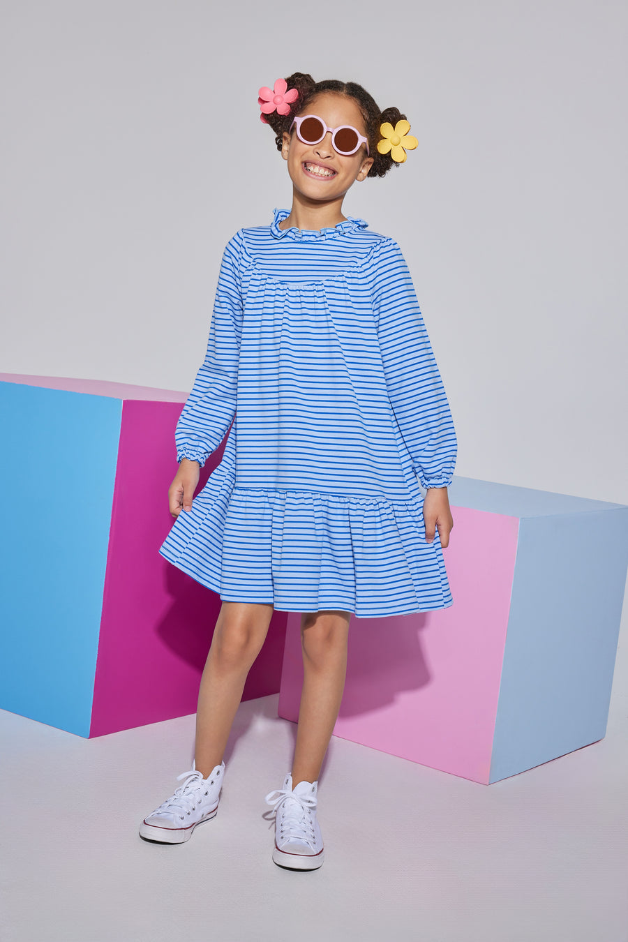 Girl/tween knit long sleeve light blue/dark blue stripe  dress that features  a ruffle neckline with a button closure at back of neck and elastic cuffs at end of sleeves.