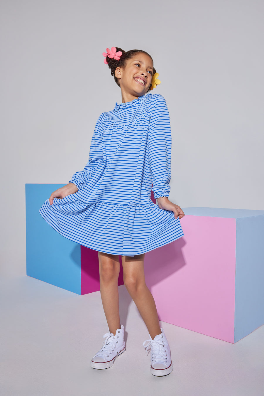 Girl/tween knit long sleeve light blue/dark blue stripe dress that features a ruffle neckline with a button closure at back of neck and elastic cuffs at end of sleeves.