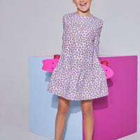 Girls/tween woven dress in light pink/purple/yellow floral print featuring long sleeves and button closures along back.