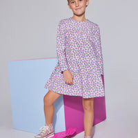 Girls/tween woven dress in light pink/purple/yellow floral print featuring long sleeves and button closures along back.