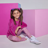 Girls/tween knit leggings in a fuchsia/white floral print , made of a super lightweight stretchy material that also feature a small ricrac/scallop detail at the ankles. Leggings can be seen paired with a long sleeve magenta velour top to complete the look.