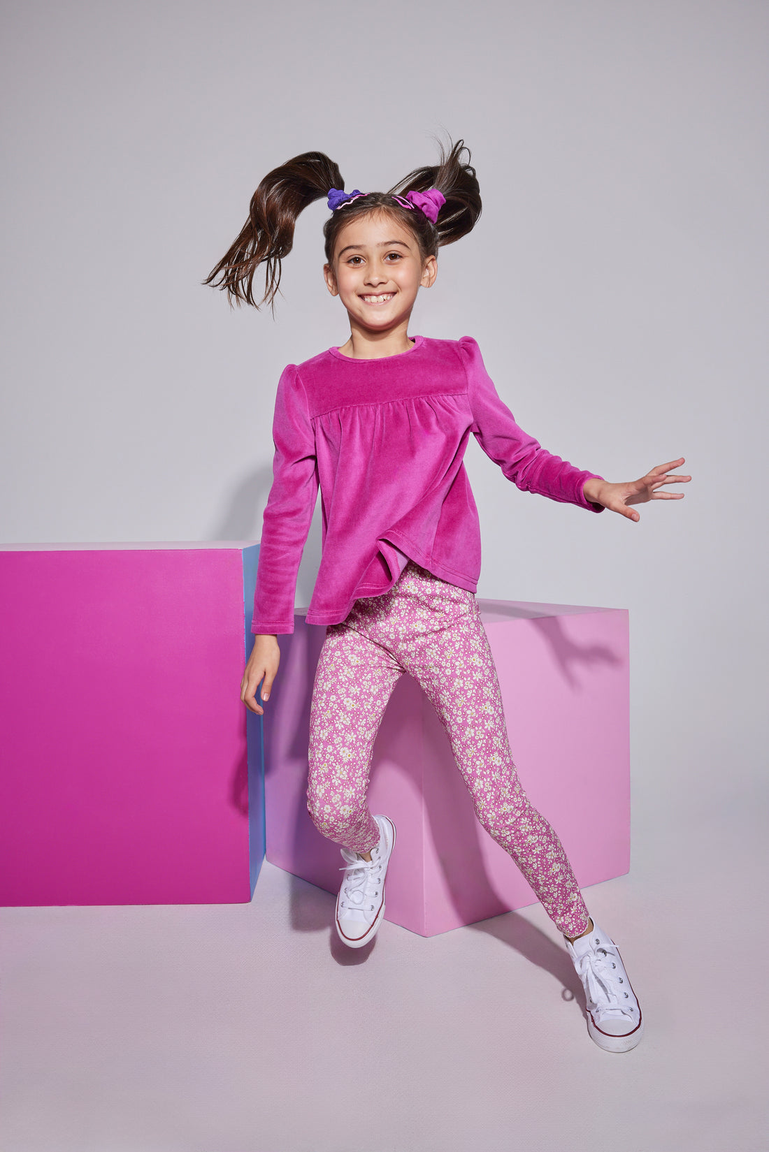 Girls/tween knit leggings in a fuchsia/white floral print , made of a super lightweight stretchy material that also feature a small ricrac/scallop detail at the ankles. Leggings can be seen paired with a long sleeve magenta velour top to complete the look.