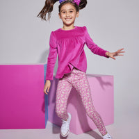 Girls/tween knit leggings in a fuchsia/white floral print , made of a super lightweight stretchy material that also feature a small ricrac/scallop detail at the ankles. Leggings can be seen paired with a long sleeve magenta velour top to complete the look.