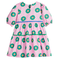 Girls/Tween woven slightly v-neck dress which features an arrangement of royal blue/green/yellow flowers on a pink background. Dress has a ric rac detail along bottom/top tier in both royal blue and green and elastic cuffs on the sleeves. Dress also has button enclosures along the back.