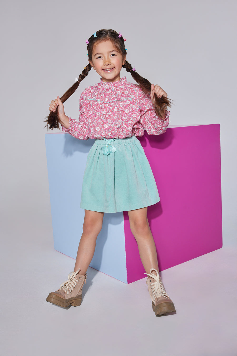 Girls/tween woven long sleeve top in a hot pink/light pink/aqua floral arrangement and features ruffles around the neckline, elastic cuffs at end of sleeves, and gathering detail at the bust for a relaxed fit. Shirt pairs back well with skirt in aqua velvet to complete the look.