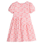 Girls/Tween knit asymmetrical cut dress in a salmon/pink color with big white flower print. The cuffs at sleeves are elastic and there is a zipper along back for a relaxed but secure fit. 