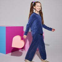 Girl/Tween cropped velour pants in a navy velour color. Pants feature an elastic waistband and pockets in the front of the pants. Material is also made of a very soft/warm velour. Model can be seen pairing pants with the matching polo pullover in the same navy velour to complete the look.