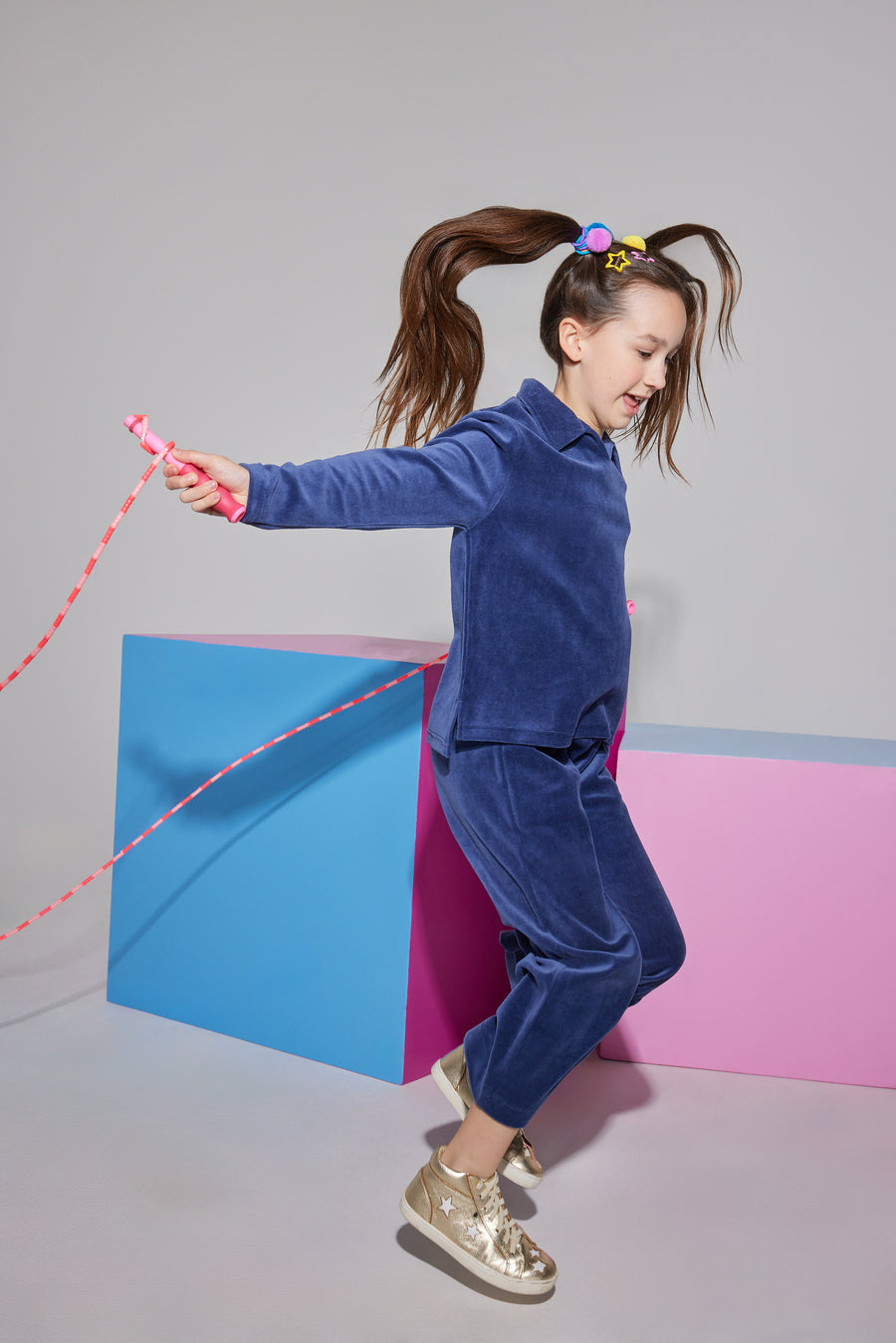 Girls/Tween velour pullover in a navy color. The pullover features a v-neck neckline and a collar, so girls can wear a turtleneck underneath if desired. Paired back perfectly with the matching cropped velour pants in the same navy shade.