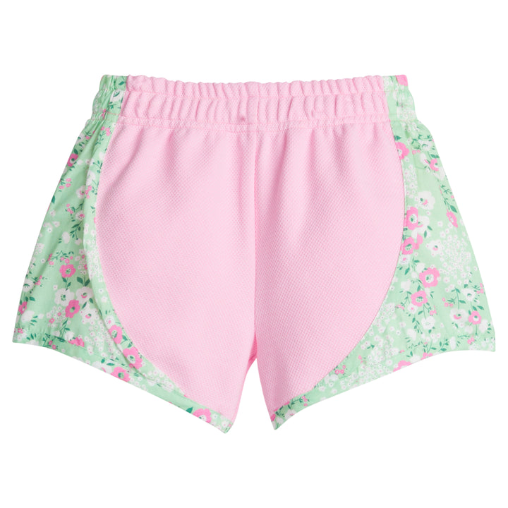 Girl/Tween basic pink athletic type track short with green/pink/white floral print along outside of shorts. 