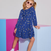 Girls/Tween corduroy dress in a navy color with gold stars printed on it. Dress features gold button closures down the front of dress, elastic cuffs at sleeves, and a slight ruffle detail at bust