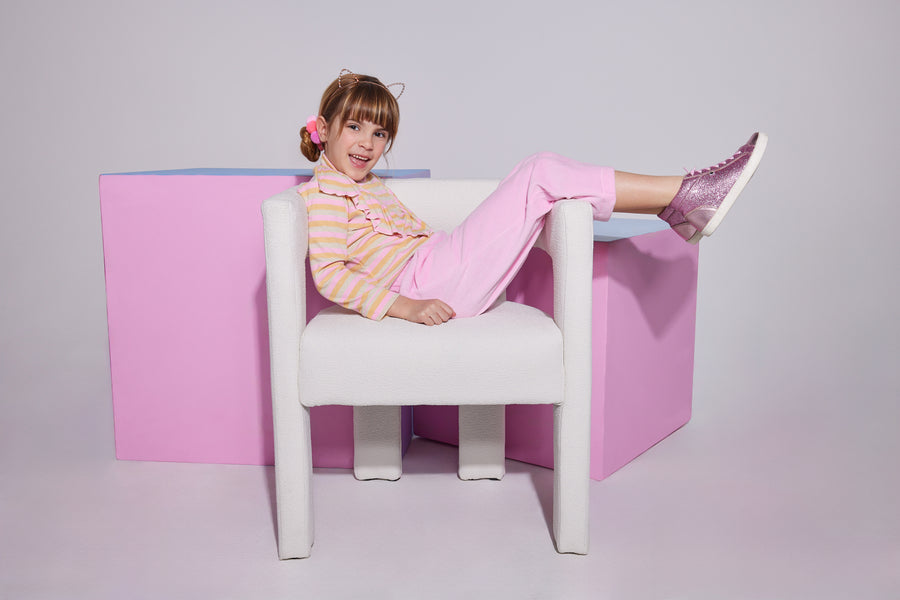 Girl/Tween cropped velour pants in the light pink velour shade. Pants feature a soft velour material, with pockets in the front, and an elastic waistband for a comfy fit. Model can be seen wearing a knit top with angel sleeves in a pastel stripe pattern to complete the look. 